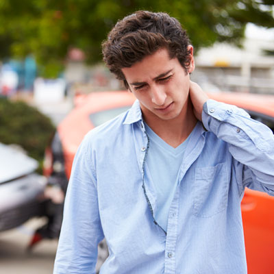 Young man holding neck after accident