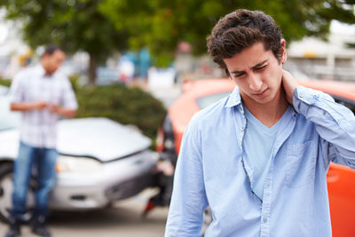 young man holding neck in pain after car wreck