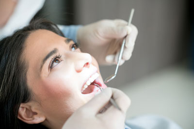 young woman having teeth cleaned