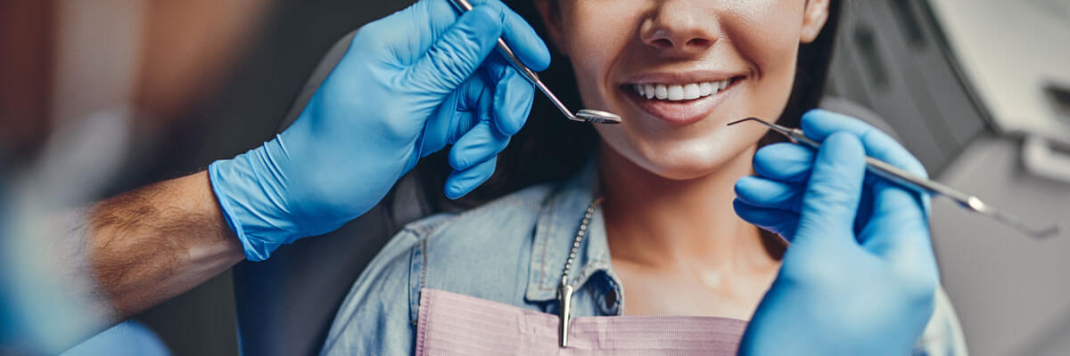 close up of mouth of young woman in dental chair smiling