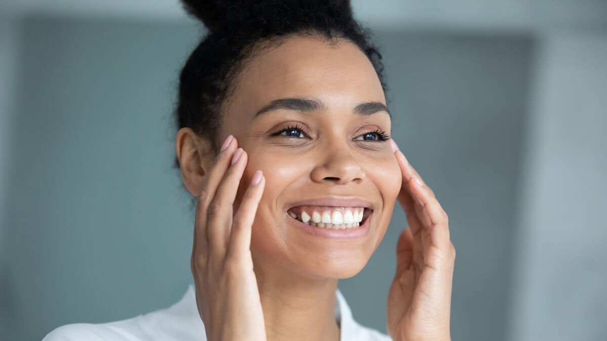 smiling person with their hands on cheeks