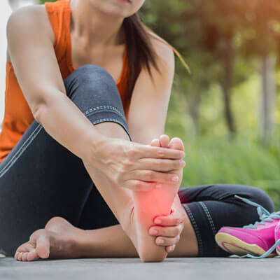 woman holding foot in pain
